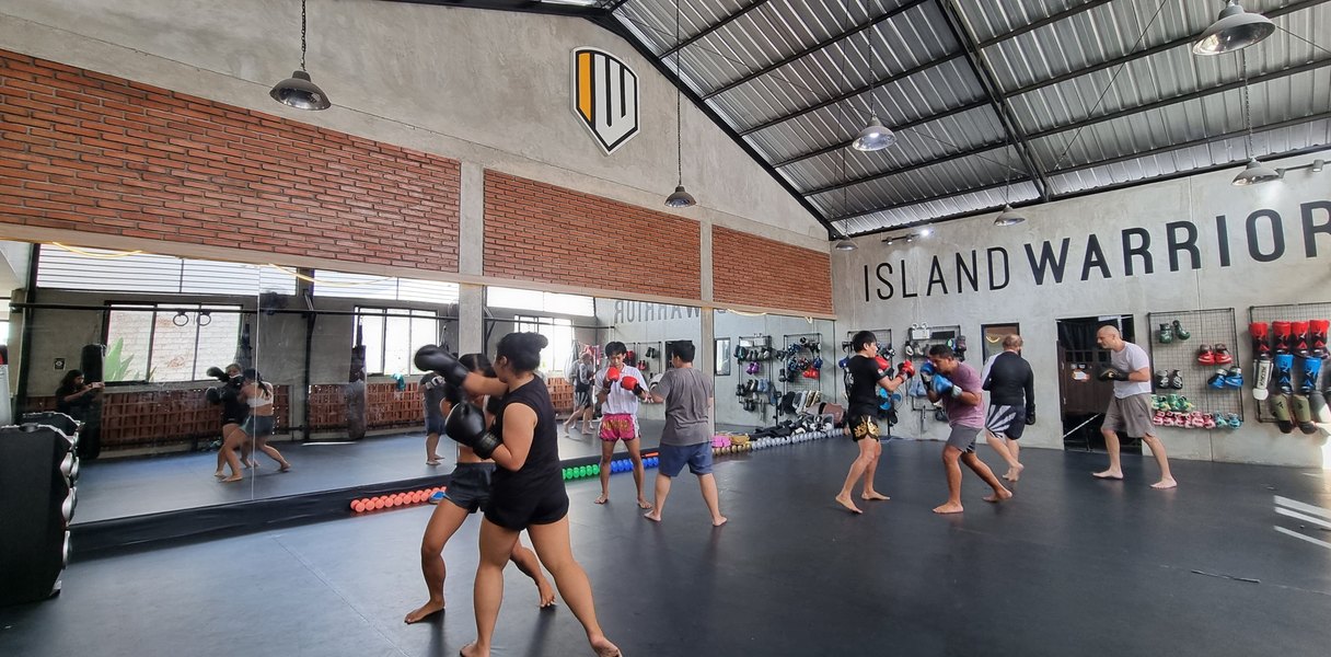 Group Muay Thai class training on the matted floor of the Island Warrior Bali Renon camp