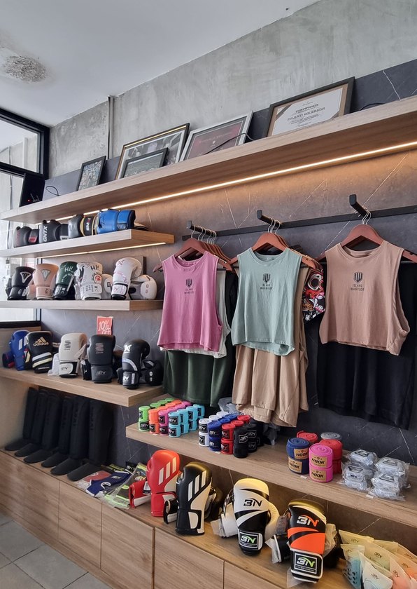 Pro shop shelves stocked with Island Warrior Bali apparel, boxing gloves and hand wraps